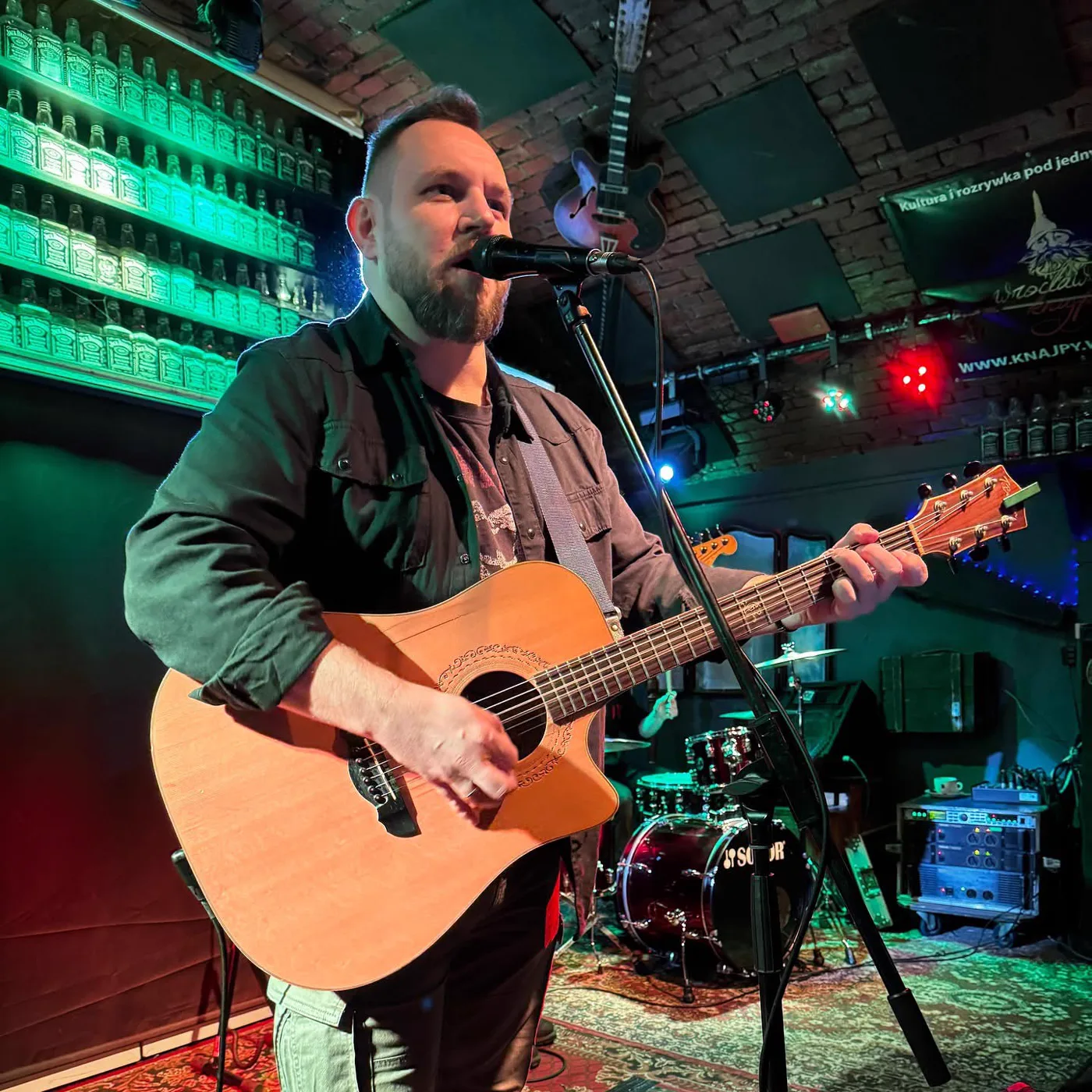 Grzegorz Komar Sikorski na scenie z gitarą